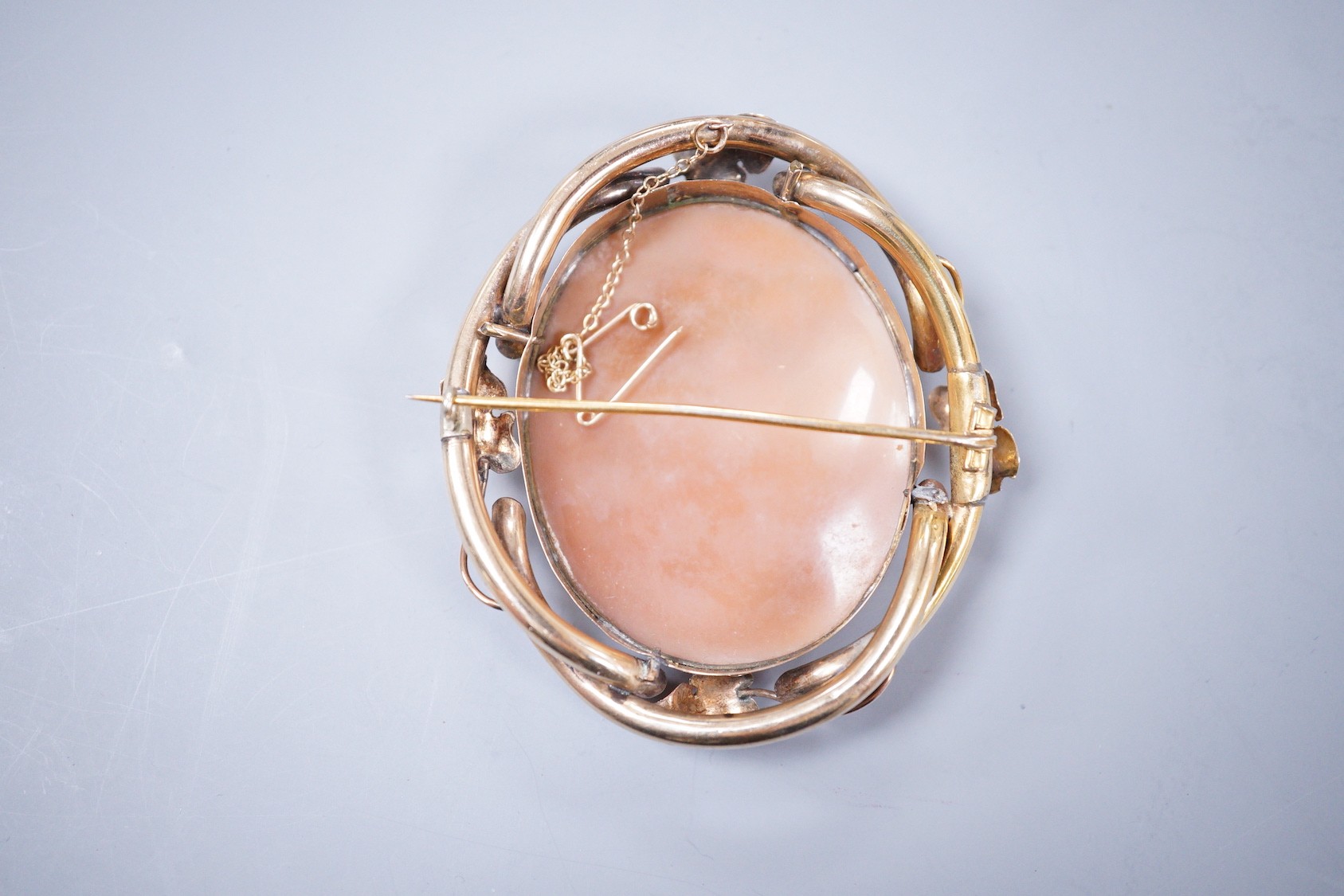 A Victorian yellow metal mounted oval cameo shell brooch, carved with Madonna and child with a young St. John, 70mm